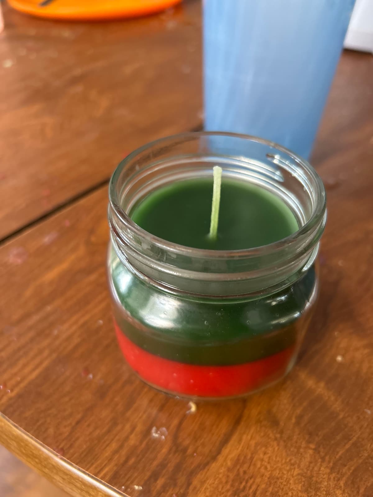 Custom two-tone layered candle in clear glass jar showing red and green layers