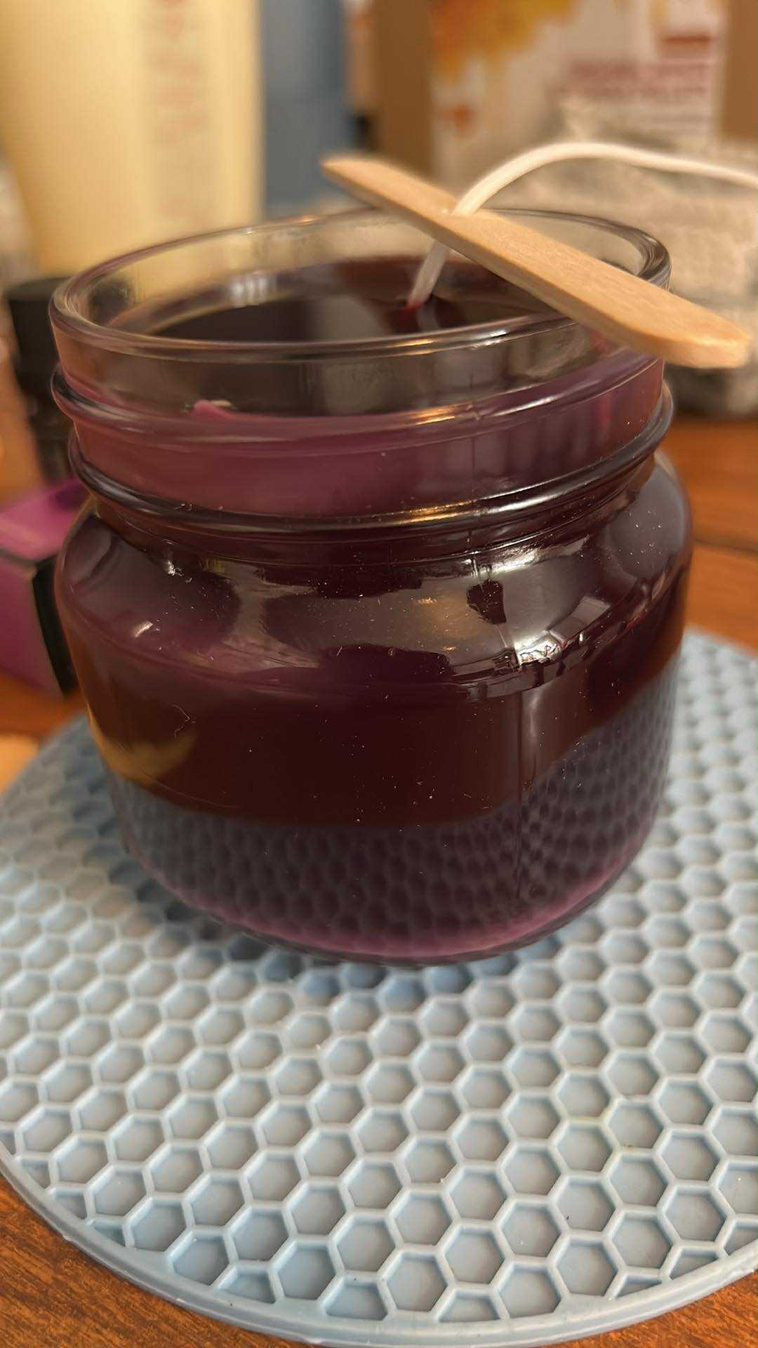 Handmade purple candle being crafted with love and prayer